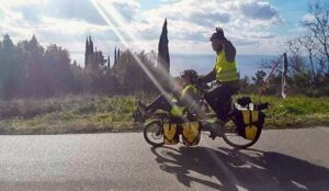 Touring cyclist riding on the road and waving