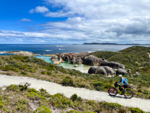 Bicyclist riding on path near the sea