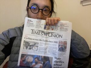 Man holding newspaper featuring article about him