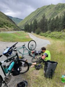 Bicyclist by the side of the road fixing a flat tire