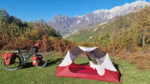 Campsite with tent and touring bicycle in a mountain meadow