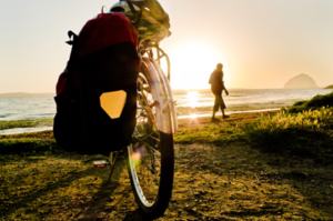 A touring bicycle parked at the beach at sunset