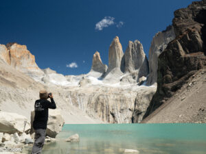 Man photographing a lake in front of sand dunes