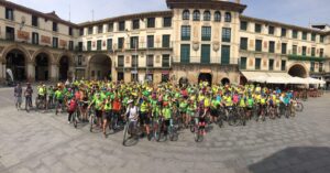 A group of bicyclists posing together in front of a building