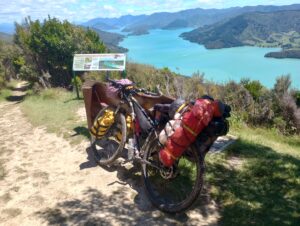A loaded touring bicycle at the top of a mountain overlooking a lake