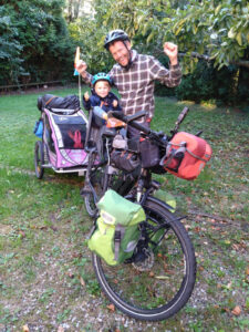 Father and son on loaded touring bicycle ready to ride.