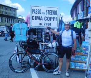 Man posing with his loaded touring bicycle in a busy city center market