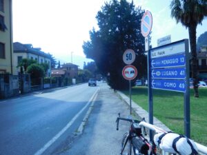 Man riding a touring bicycle on a town road in Italy