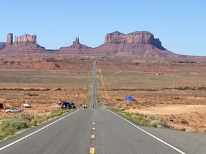 An empty paved road running through the desert with a view of rock formations. Considered to be Forest Gump Hill