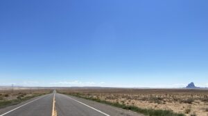 An empty paved highway running through the desert.