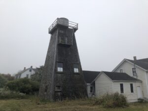 A tall wooden water tower attached to a home