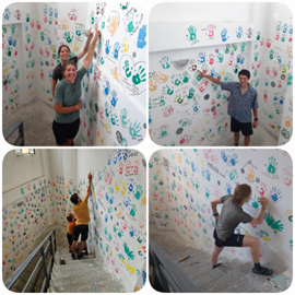 People painting their handprints on the stairway walls