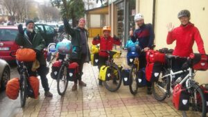 A group of touring bicyclists posing with their bicycles