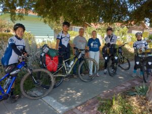 A group of cyclists posing with their loaded touring bicycles