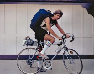 A young man on his bicycle wearing a huge backpack