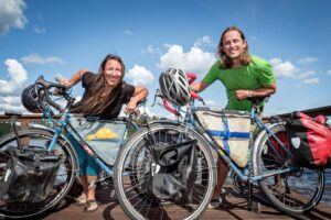 Two people posing with their loaded touring bicycles