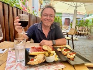 Man sitting at an outdoor cafe eating dinner