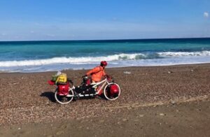 Man with a loaded tandem touring bicycle on the beach