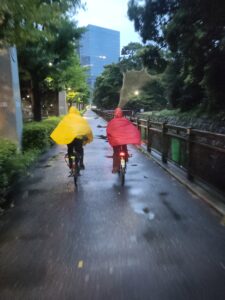 man and woman riding bicycles in the rain