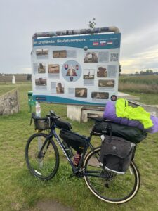 Loaded touring bicycle propped in front of a directional sign