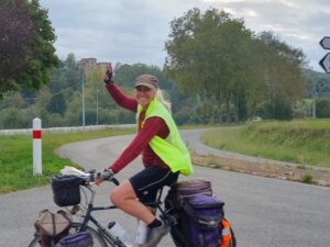 Woman riding a bicycle and waving
