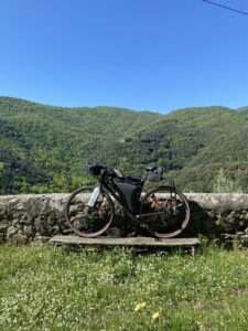 A bicycle leaning against a stone wall overlooking a valley