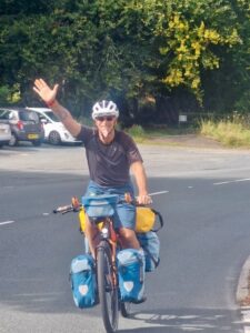 Man riding bicycle and waving