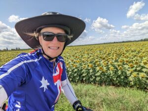 A woman riding her bicycle through the field