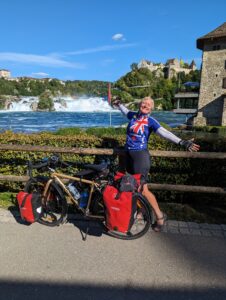 A woman standing with her bicycle overlooking a fountain