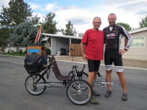 Two people and a bicycle in front of a house